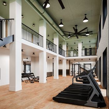 A gym with treadmills and exercise equipment in a large room